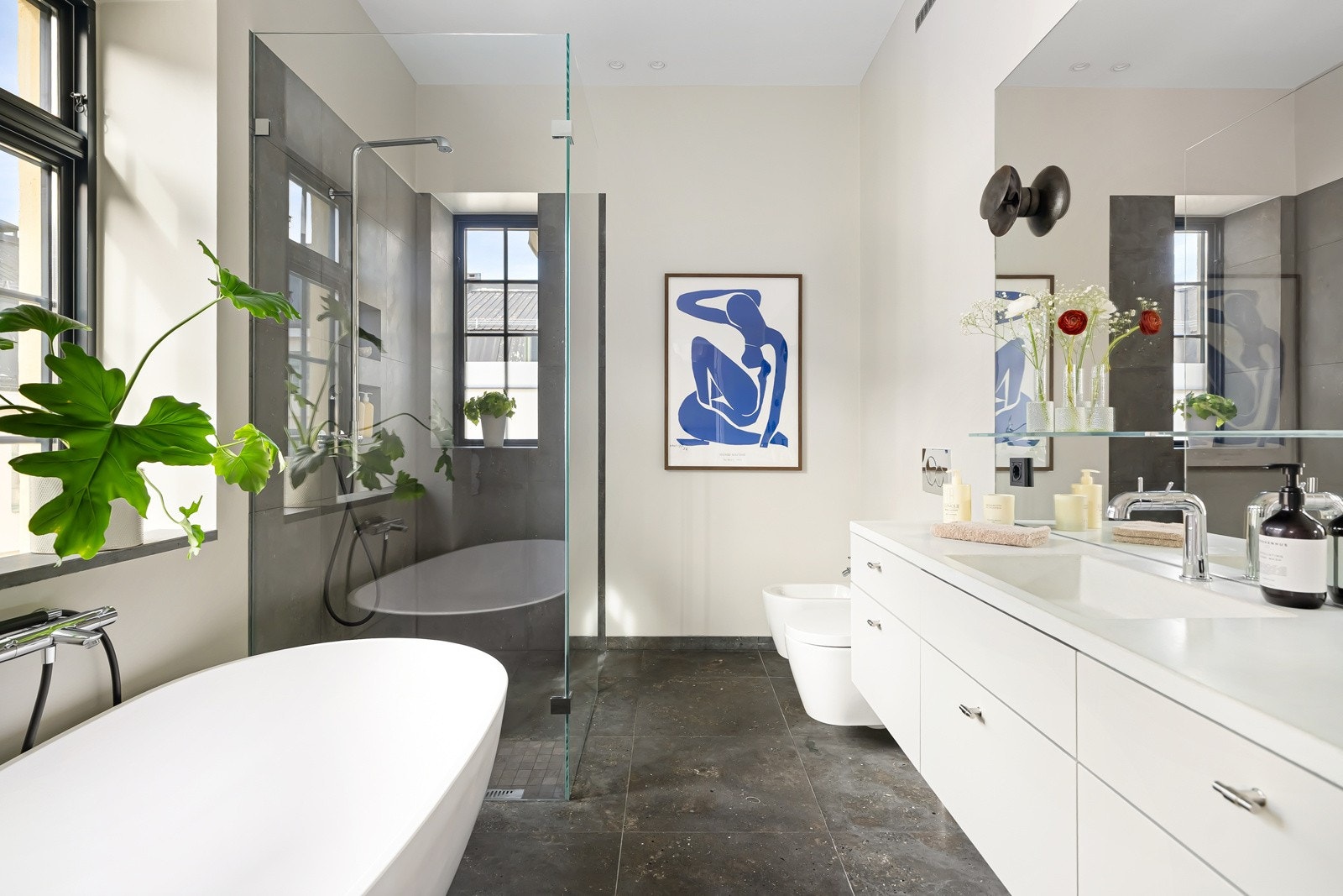 Romslig bad med stor dusj, badekar og to vinduer som gir rikelig med naturlig lys. En luksuriøs oase i hjemmet. Galleribilde