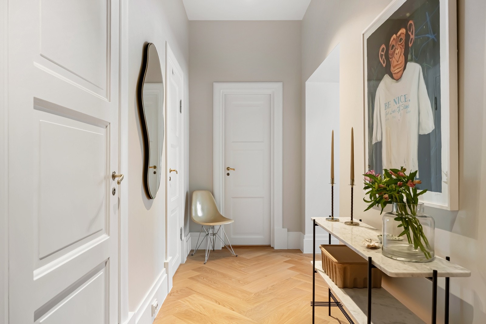 Hallen er innbydende med gulvvarme, enstavs fiskebensparkett, glatte, gråbeige veggflater og listefri himling med diskret spotbelysning. Galleribilde