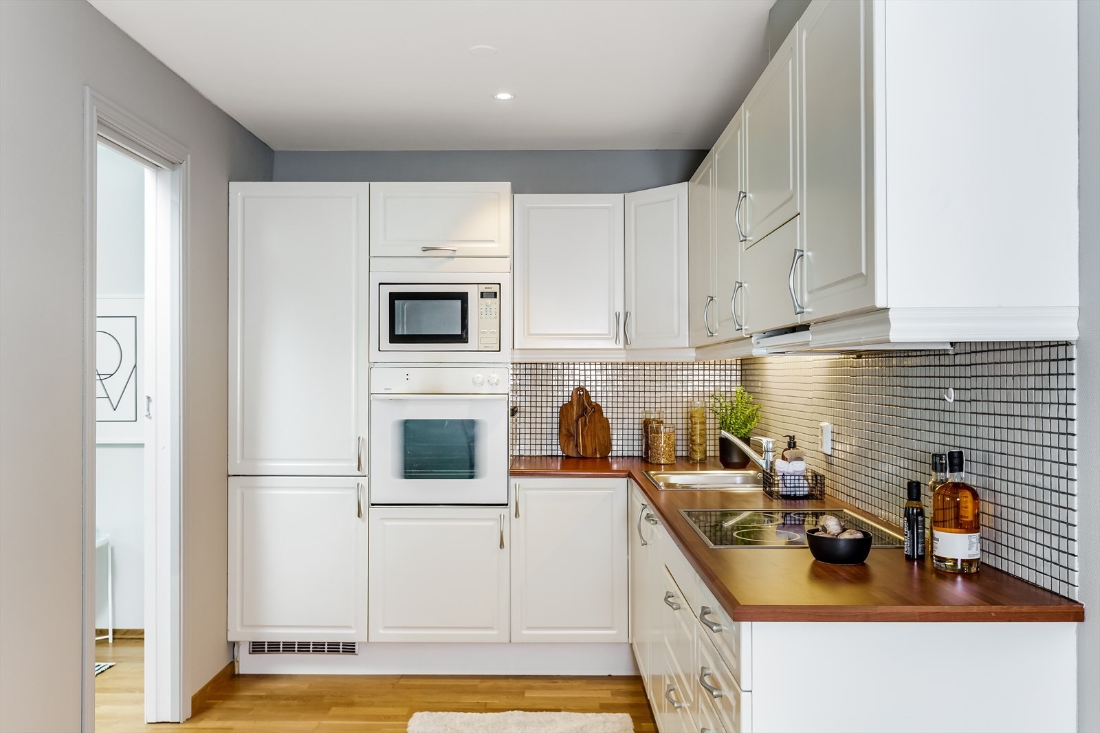 Integrerte hvitevarer som komfyr, oppvaskmaskin, mikrobølgeovn steketopp og kombinert kjøle/fryseskap medfølger handelen. Galleribilde