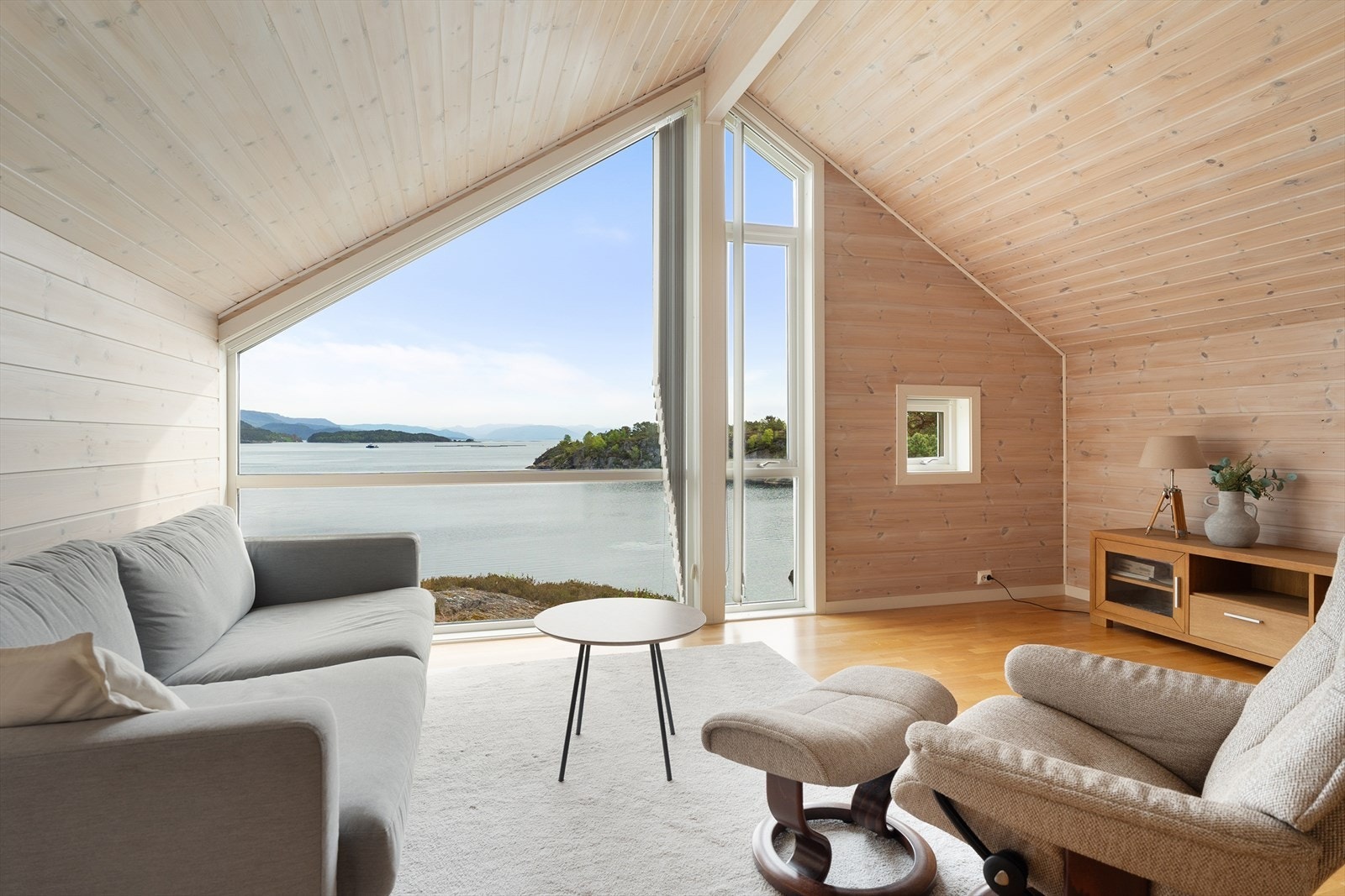 Opp trappen kommer en til herlig tv-stue med stigende takhøyde opptil 3,1 m og stort vindu mot sjøen Galleribilde