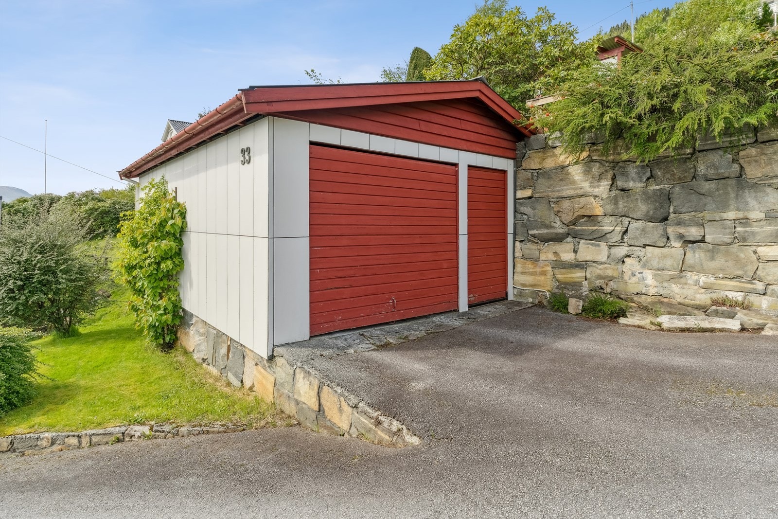 Frittståande garasje med enkel standard, biinngang og vippeport med portopnar. Galleribilde