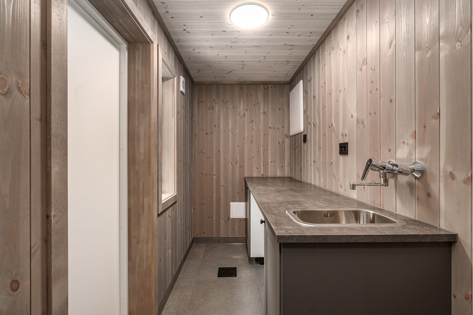 Vaskerom/bod med inngang fra bad og til og med egen utgang ut. Galleribilde