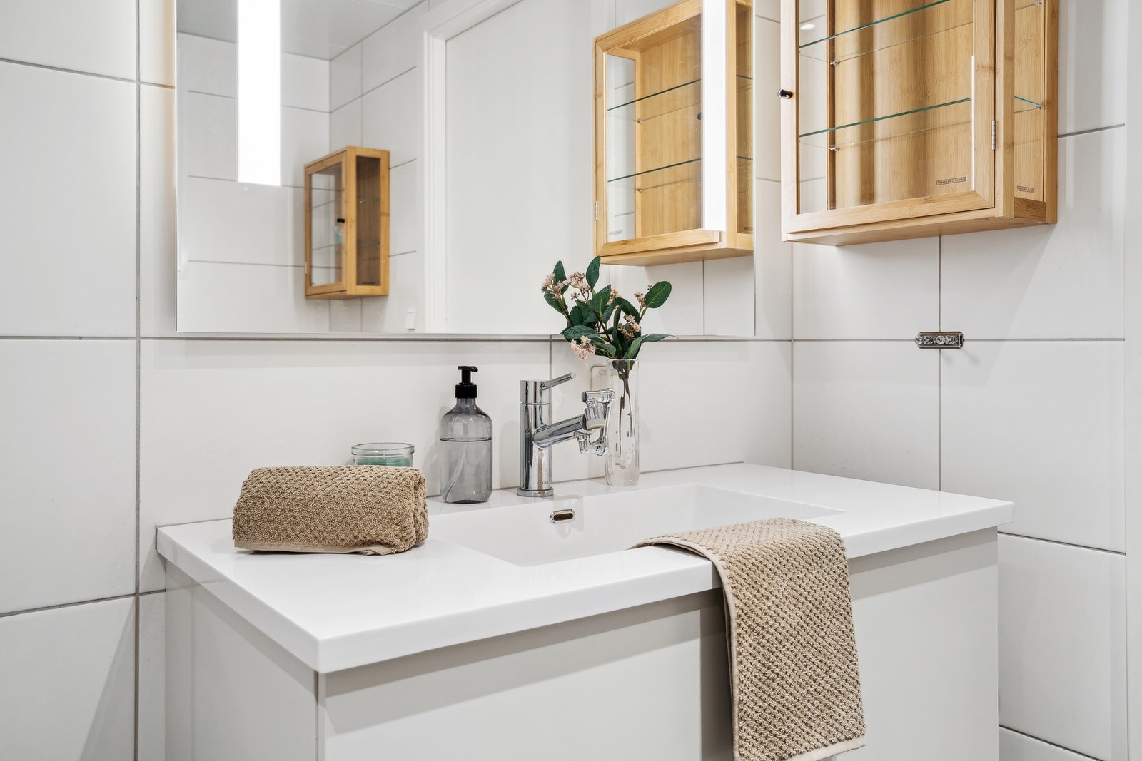 Baderommet er utstyrt med vegghengt servantinnredning, vegghengt toalett og dushjørne med dører. Galleribilde