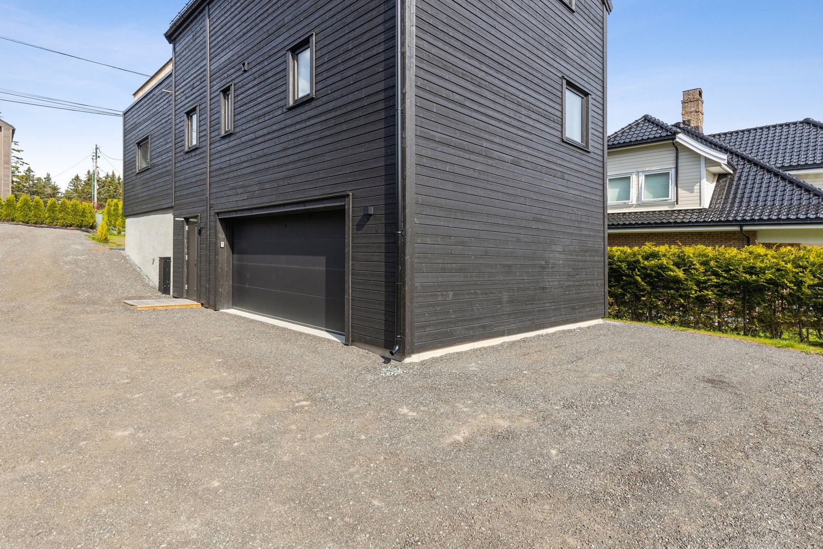 Grusplassen ved kortsiden hører til denne boligen. Det er morgensol på denne siden. Galleribilde