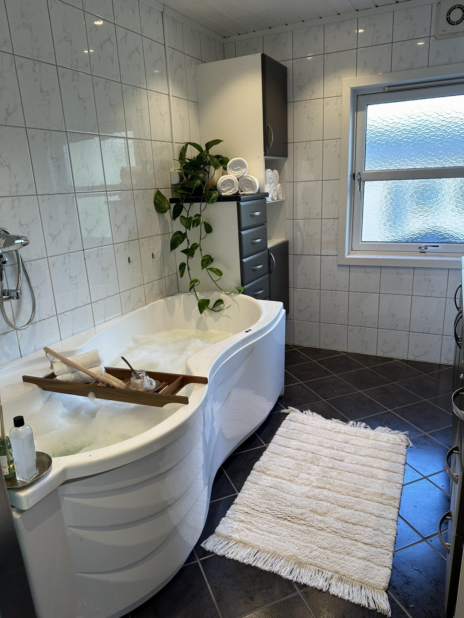 Baderommet i loftsetasjen har baderomsinnredning som byr på rikelig med oppbevaringsplass og badekar. Selgers private bilde.