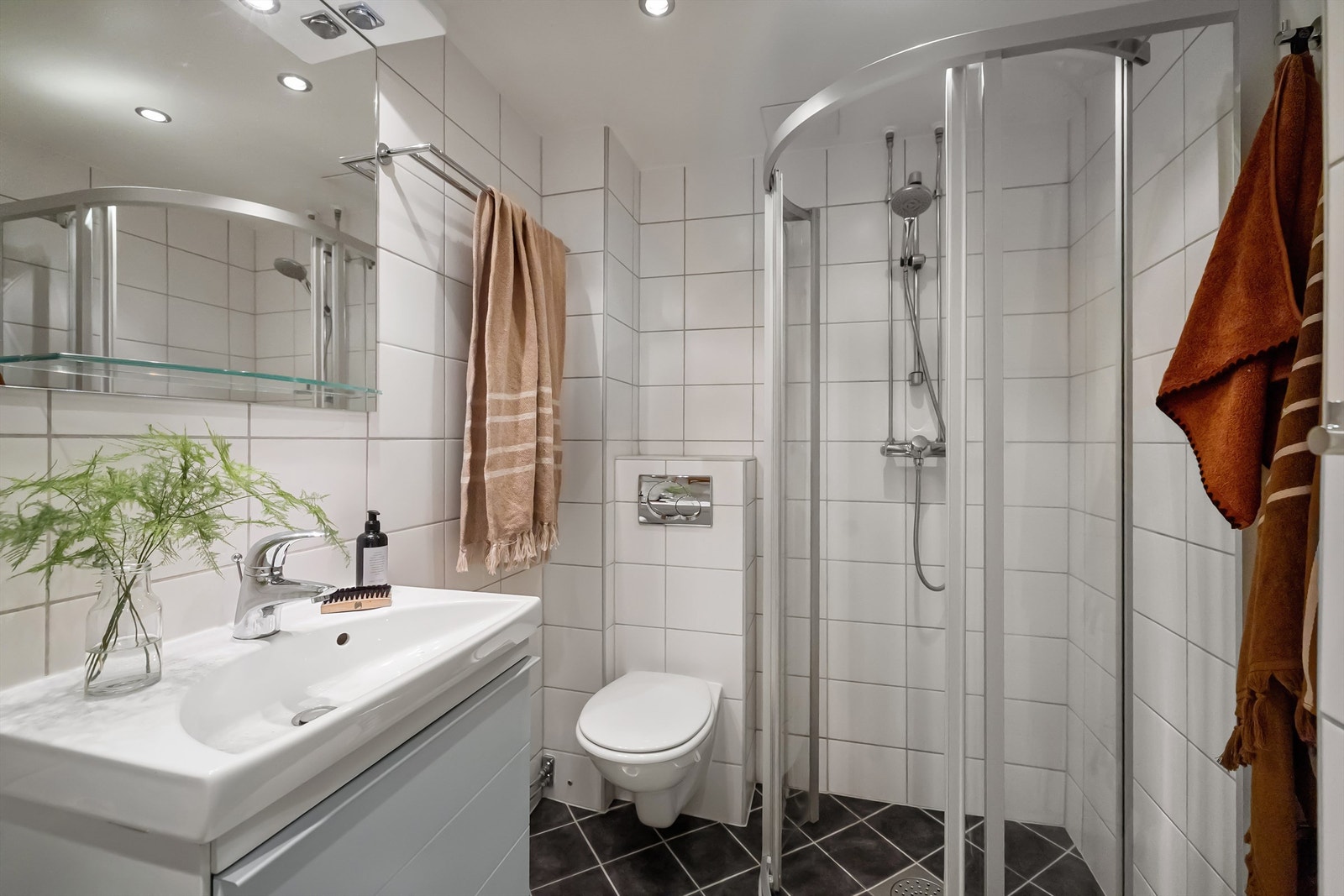 Badet ble pusset opp i regi av borettslaget i 2009 og har delikat innredning med heldekkende servant med skuffeinnredning og speil med hylle og belysning over Galleribilde