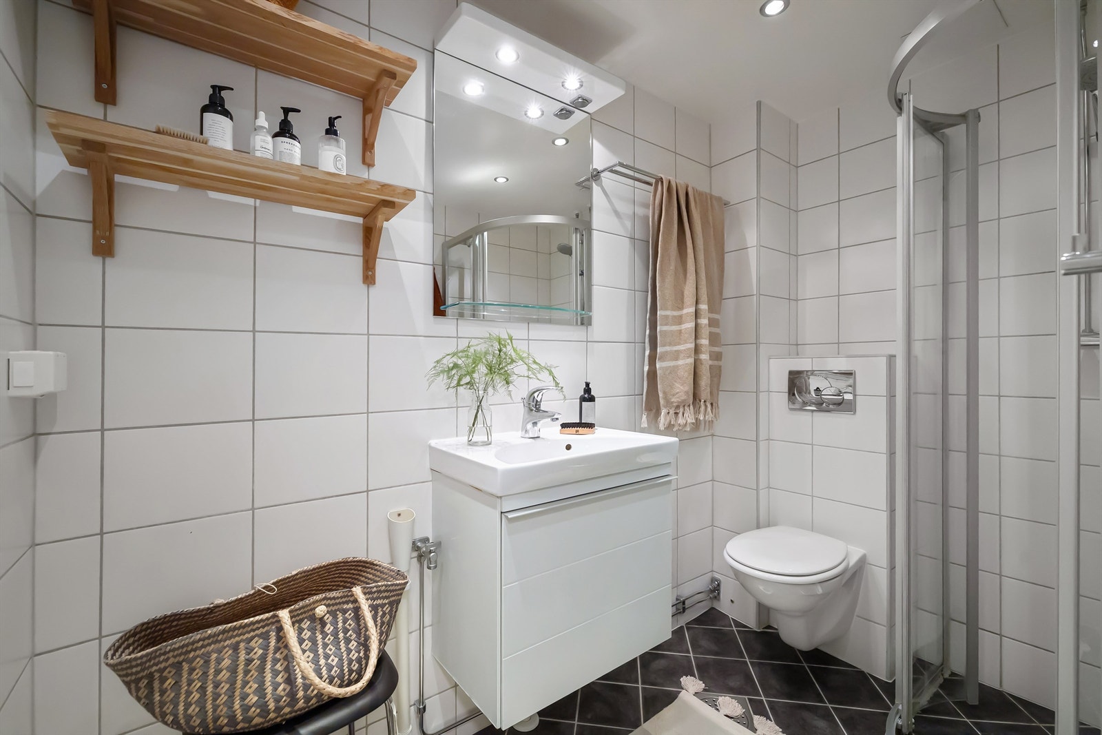 Et lyst og pent, flislagt bad med varmekabler, downlights i himling og opplegg for vaskemaskin Galleribilde