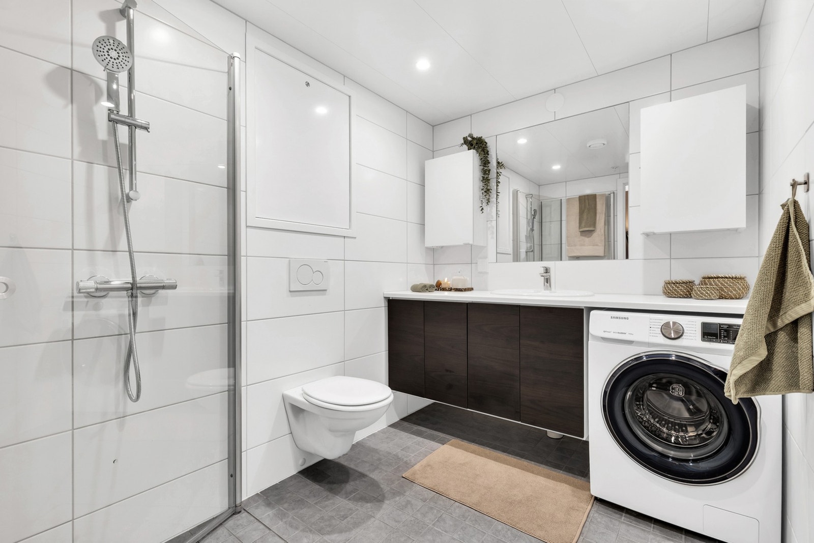 Leilighetens bad er på 4,7 kvm og har mottatt TG1. Badet er nylig oppgradert med 30x60 flis på vegg, nytt dusjarmatur og blandebatteri i servant. I tillegg er det verdt å fremheve varme i gulv, ekstra lang servantplate, godt med oppbevaringsplass i oversk Galleribilde