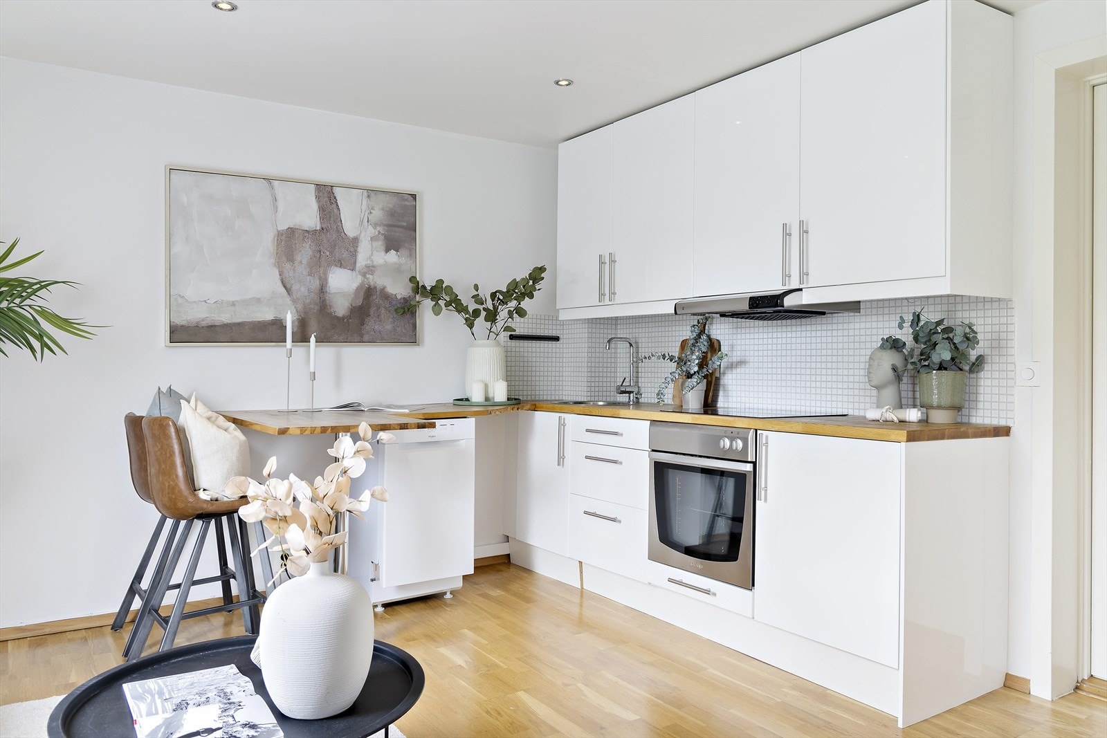 Kjøkkeninnredning med glatte fronter og stilren heltre benkeplate med nedfelt kum i rustfritt stål. Galleribilde