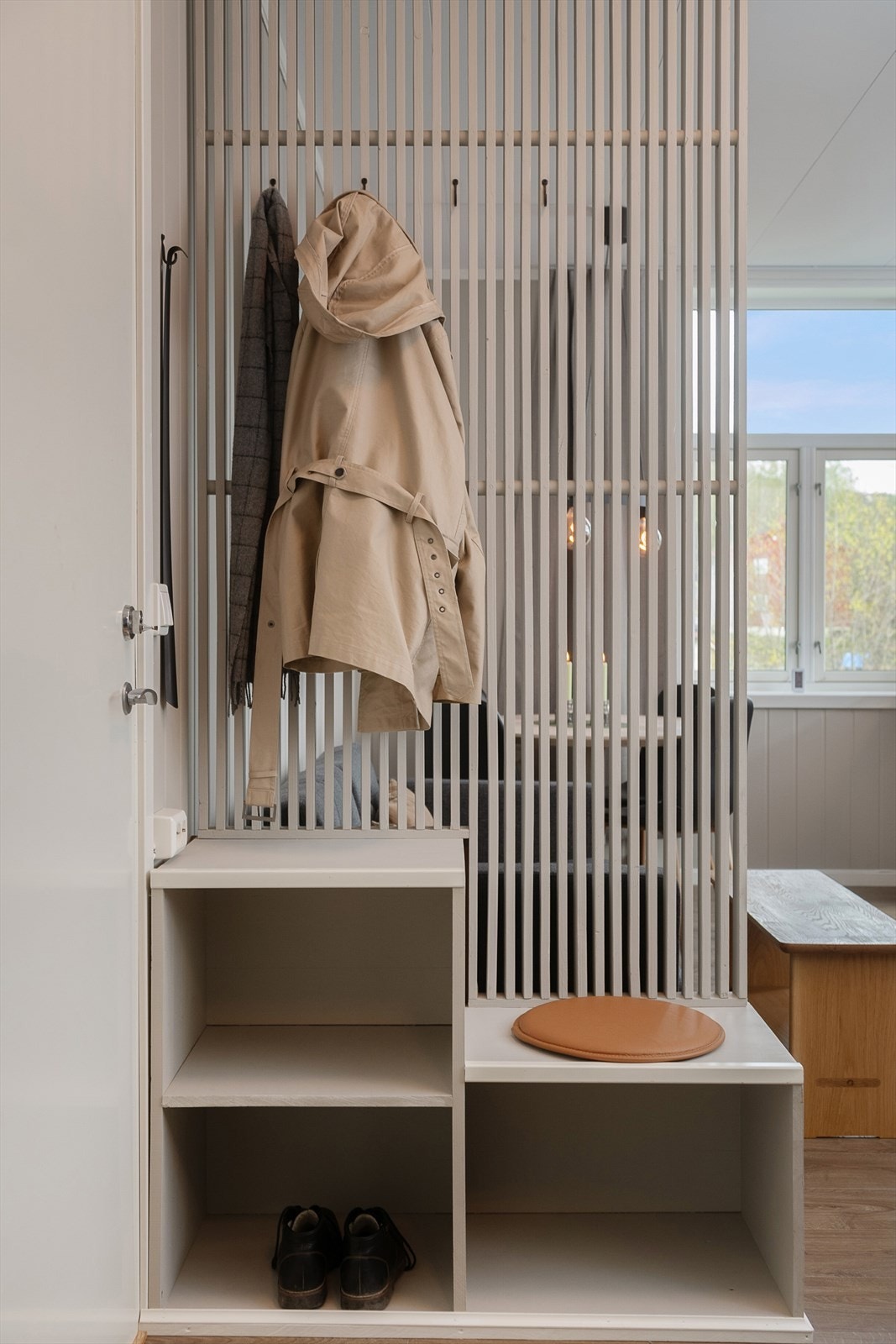 Selger har oppsatt spilevegg med skohylle for skille mellom gang og stue Galleribilde