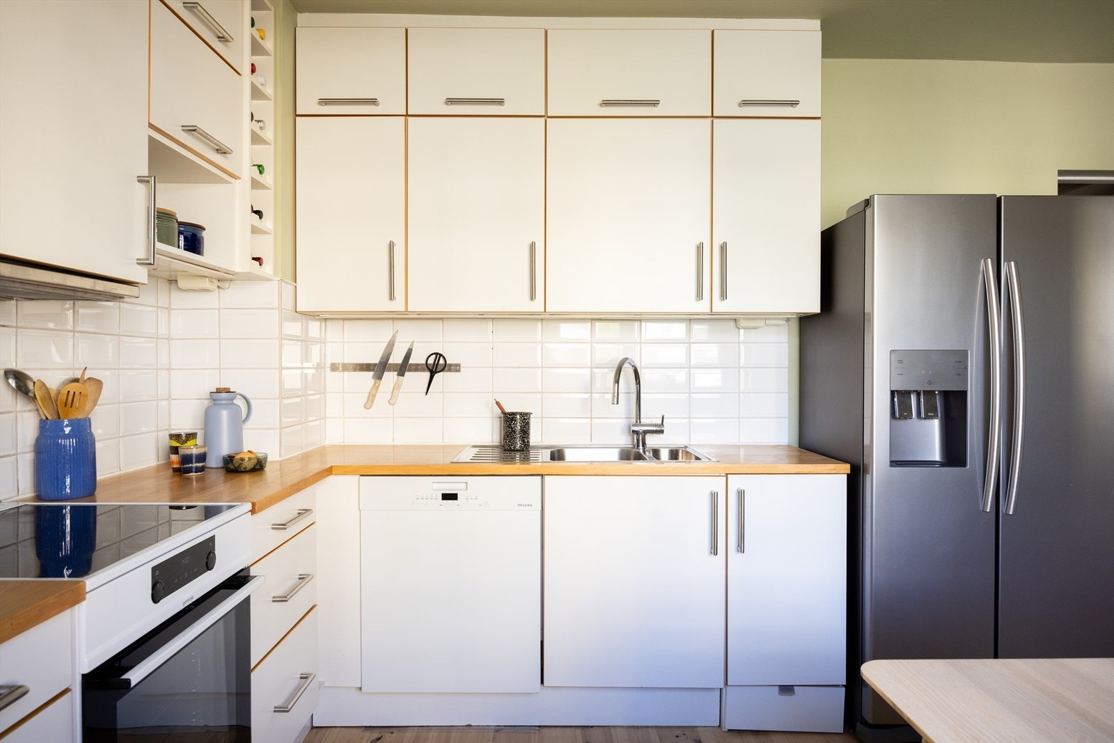 Kjøkkeninnredningen består av glatte, hvite fronter og benkeplate av laminat med nedfelt vaskekum. Galleribilde