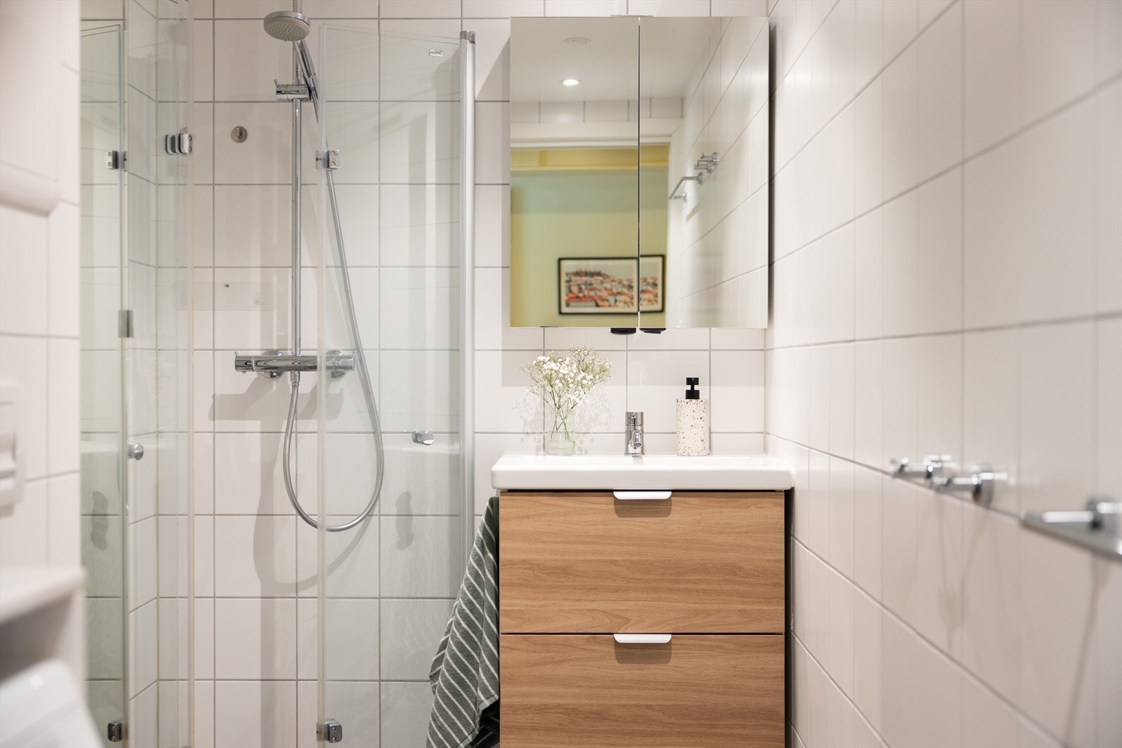 Badet er innredet med vegghengt klosett, servant på innredning, og dusjvegger/hjørne. Galleribilde