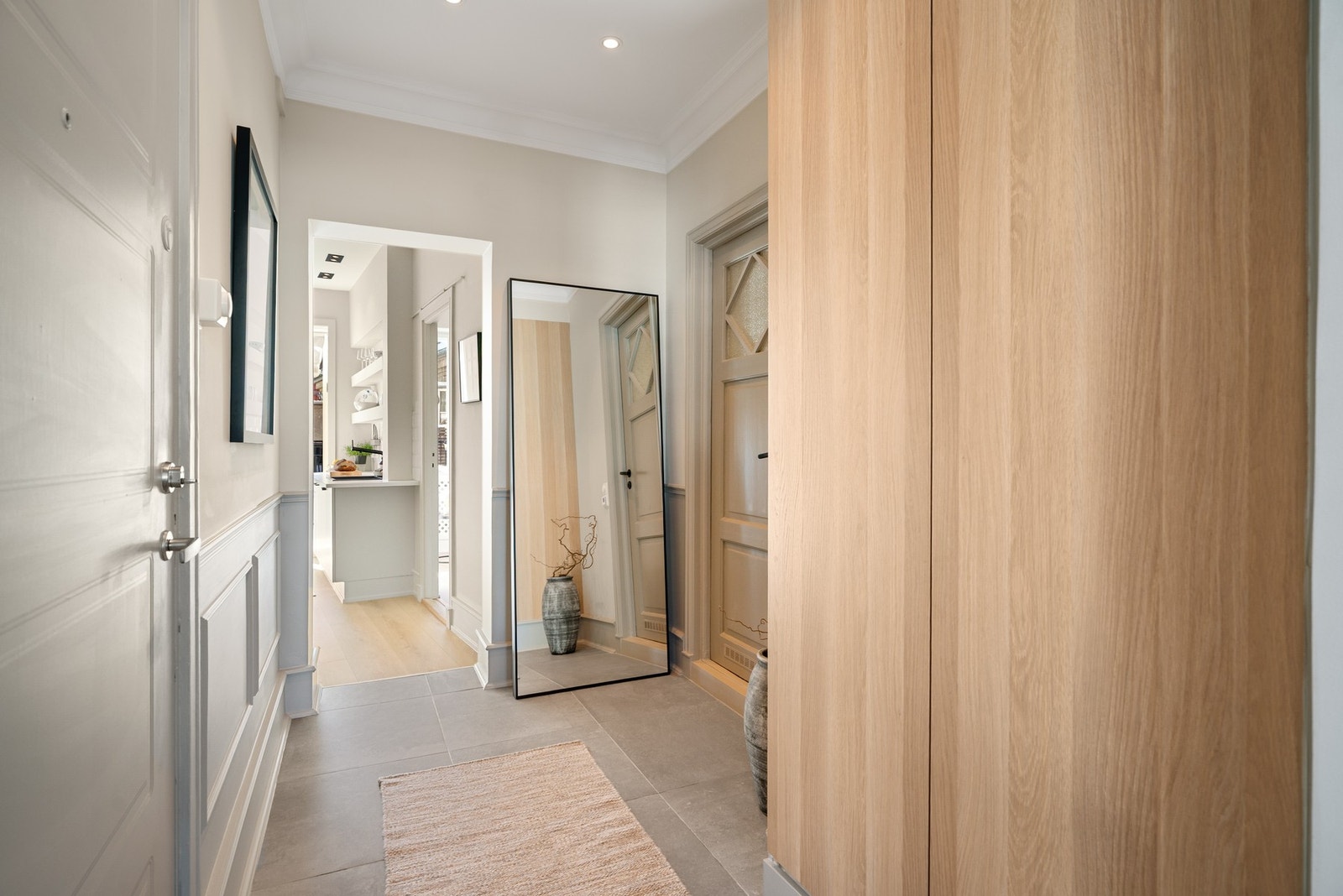 I hjerte av boligen er en hyggelig og romslig gang med flislagte gulv og downlights i himling. Galleribilde