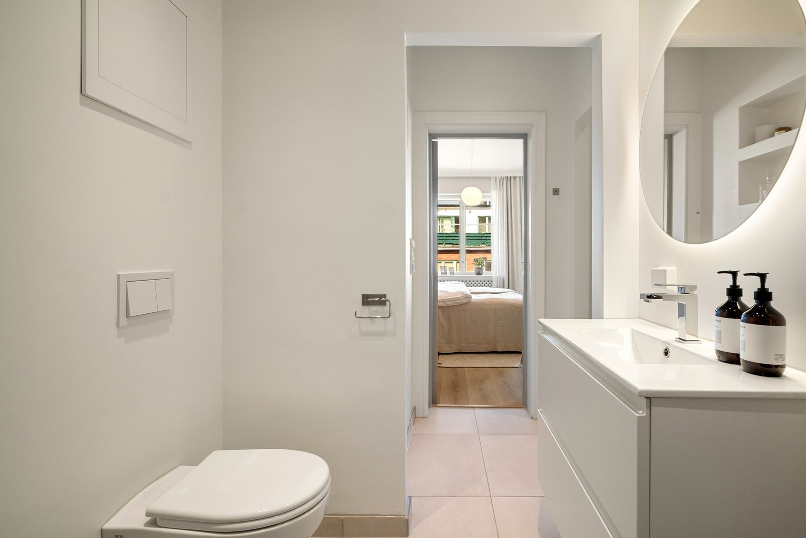 Moderne baderomsinnredning og rundt speil med integrert belysning. Galleribilde