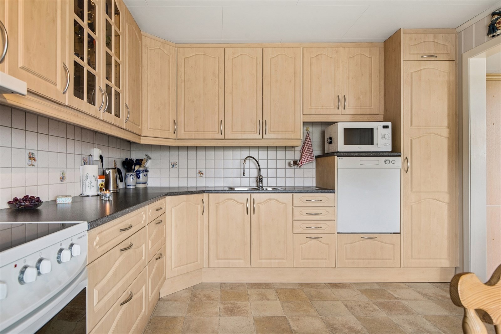 Kjøkken med pen innredning og rikelig med skap- og benkeplass. Galleribilde