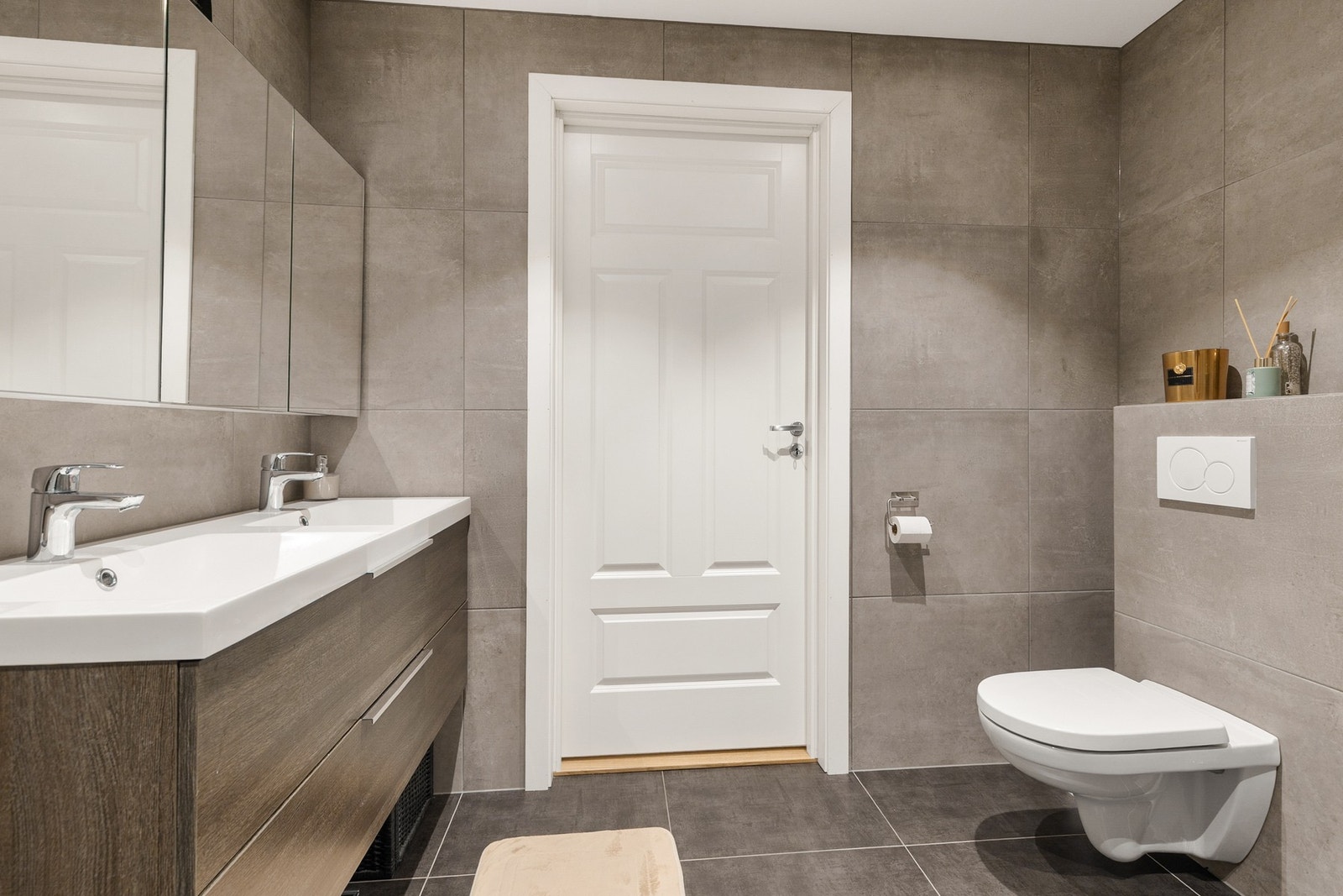 Innredningen består av en vegghengt servantskap med skuffer og en dobbel ovenpåliggende servant med ett-greps armaturer Galleribilde