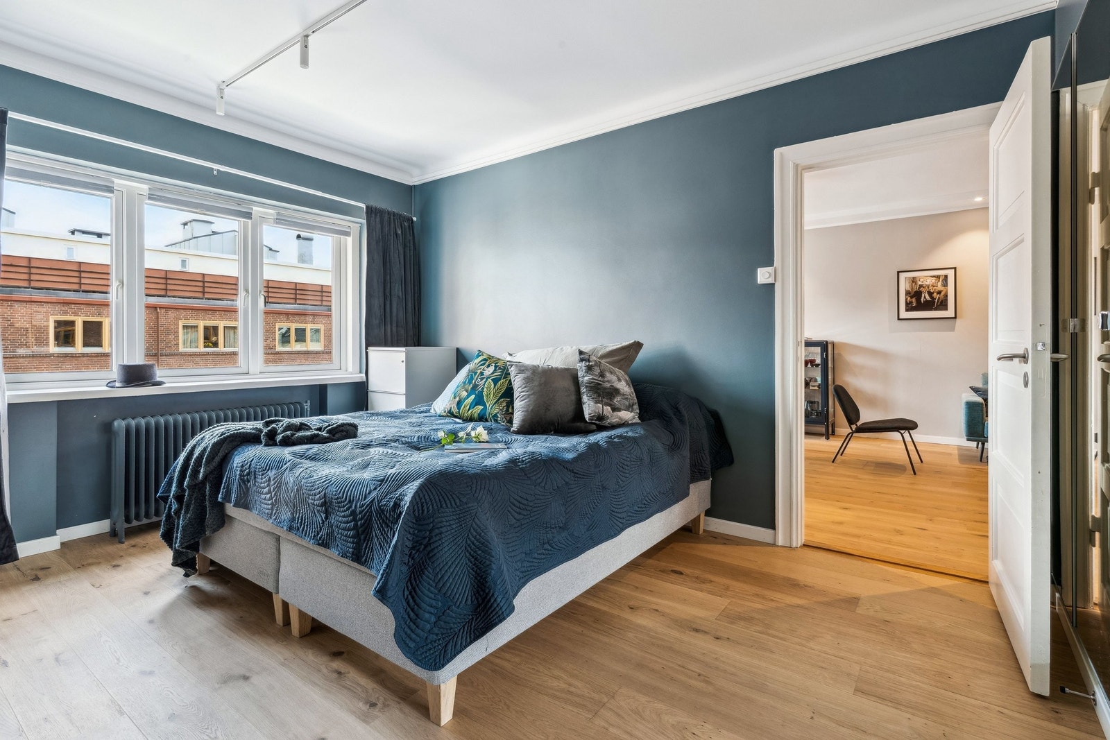 Master bedroom i smakfull blåfarge og rikelig med speilskap Galleribilde