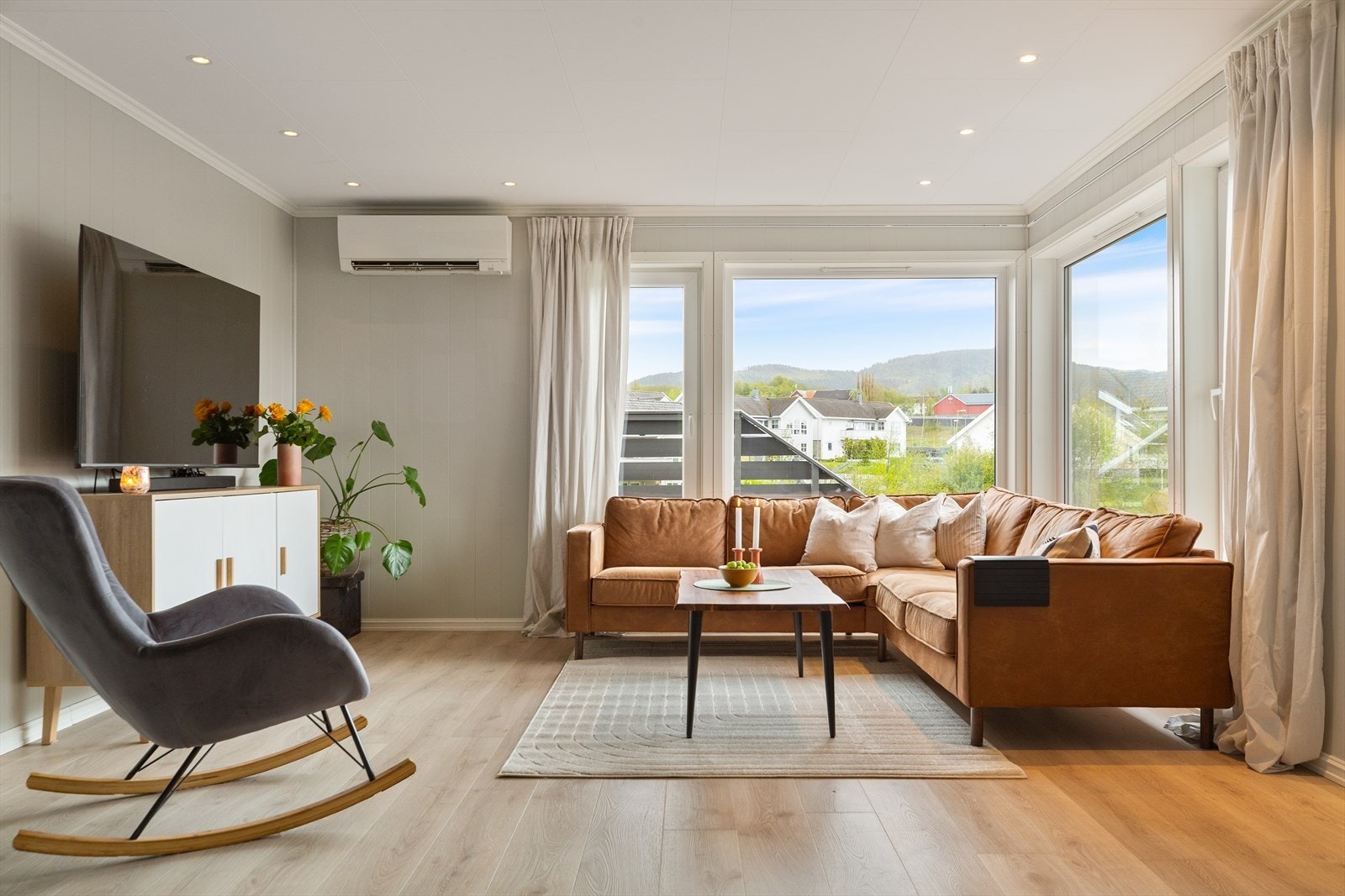 Romslig stue med god takhøyde og store vindusflater gir godt med naturlig lysinnslipp. Galleribilde