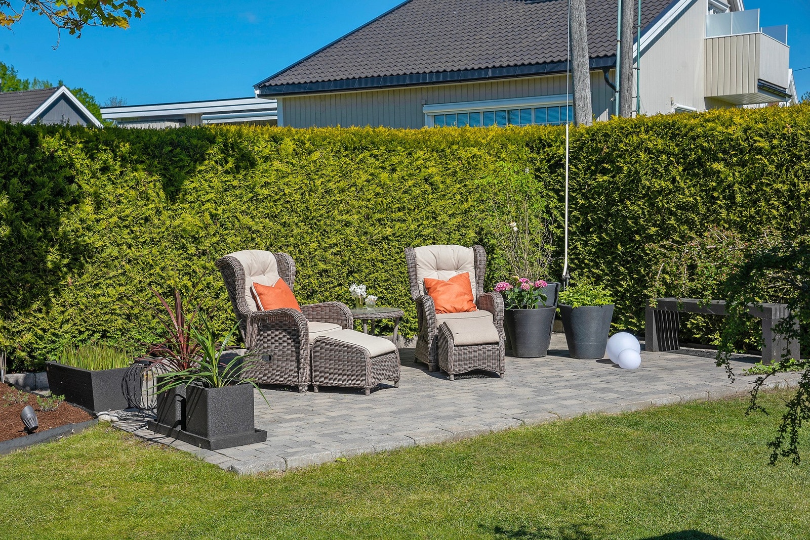 Det er flere fine uteplasser hvorav den ene er lagt i hjørnet av tomten med belegningsstein, som gir et solid, varig og stilrent underlag - perfekt for sittegruppe, grillplass eller hyggelige sammenkomster utendørs Galleribilde