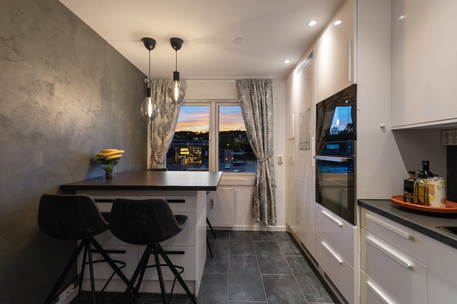 Leilighetens kjøkken ligger i et separat rom med egen spiseplass, som skaper et ekstra oppholdsrom i boligen. (Legg merke til at senteret er rett foran bygget) Galleribilde