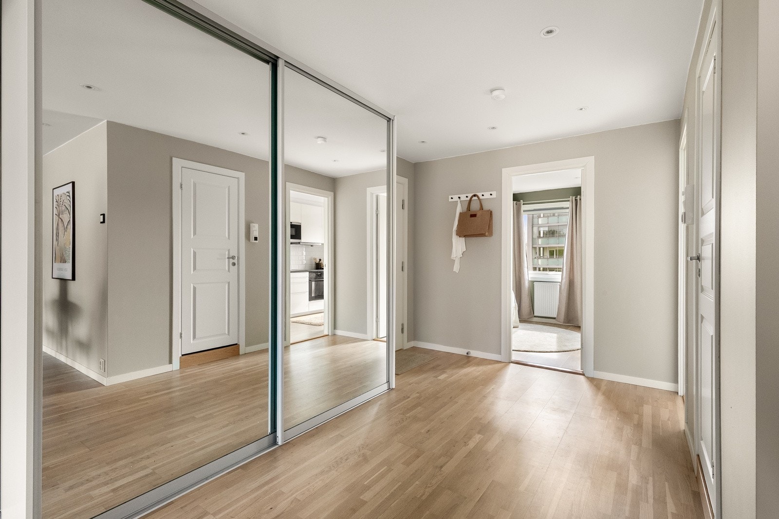 Romslig skyvedørsgarderobe med speil i entréen Galleribilde