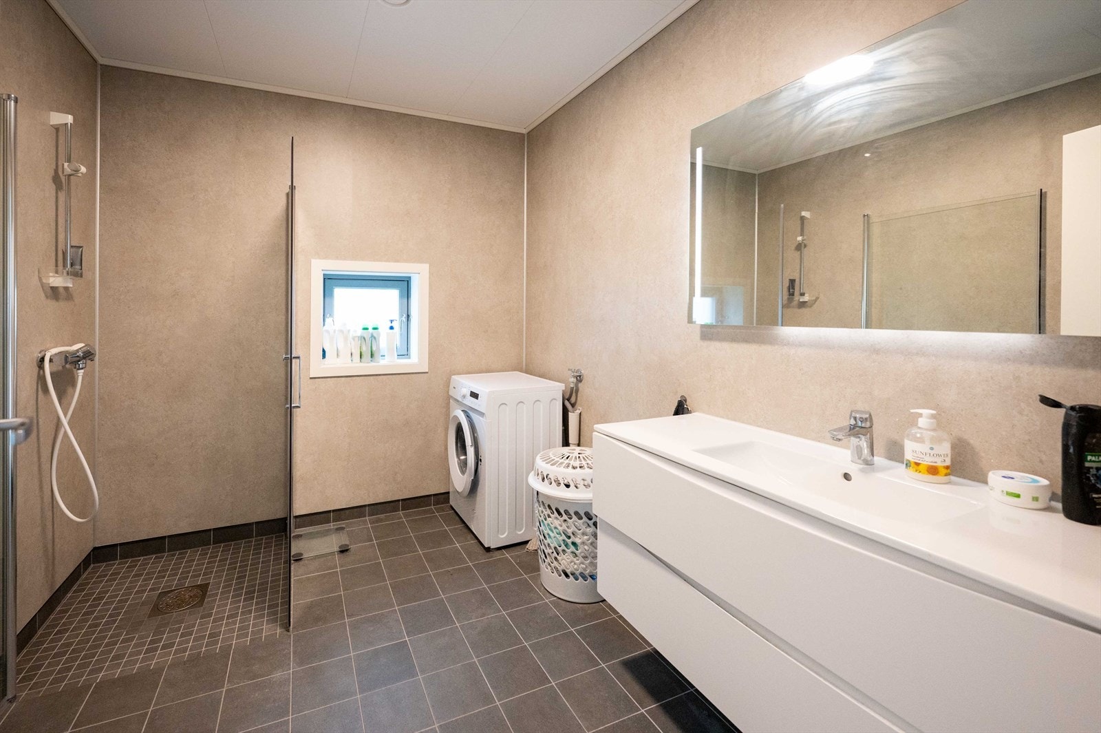 Badet er innredet med Fibo Trespo baderomsplater, mosaikkfliser i dusjsonen samt at det er lagt elektriske varmekabler i gulvet. Galleribilde