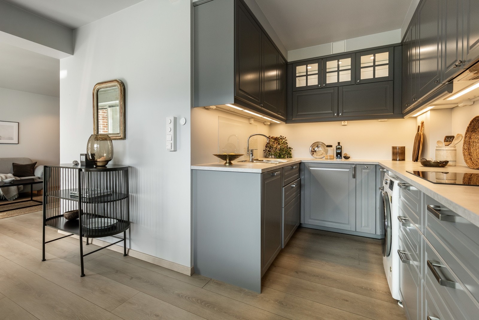 Innredningen har delikat design med grå profilfronter, vitrineskap og steinimiterte laminatbenkeplater. Galleribilde