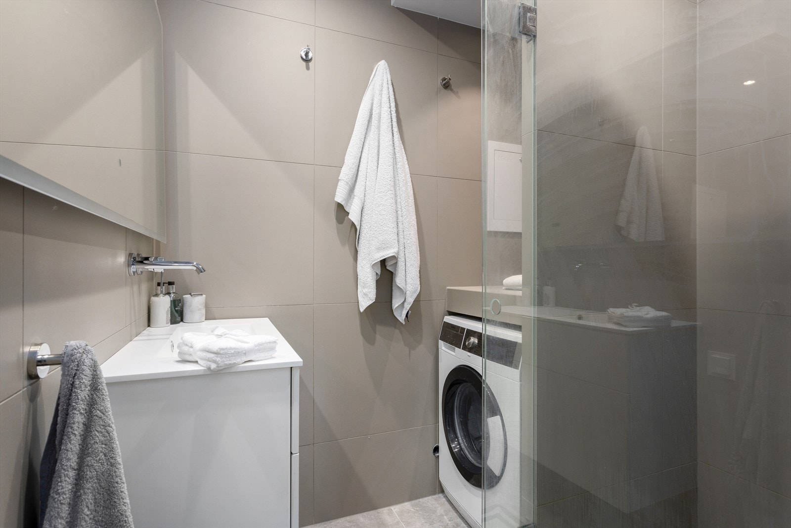 Downlights og malt overflate i himling sammen med elektrisk gulvvarme skaper en lun og funksjonell atmosfære på badet. Galleribilde