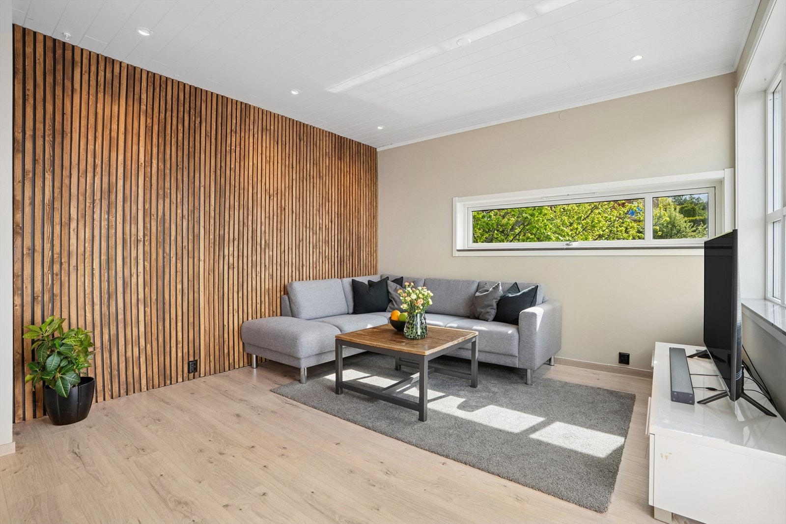 Stuen har plass til både en romslig sofagruppe og en praktisk spisegruppe. Overflatene i stuen er med lyse vegger og spilevegg som gir rommet et moderne preg. Galleribilde