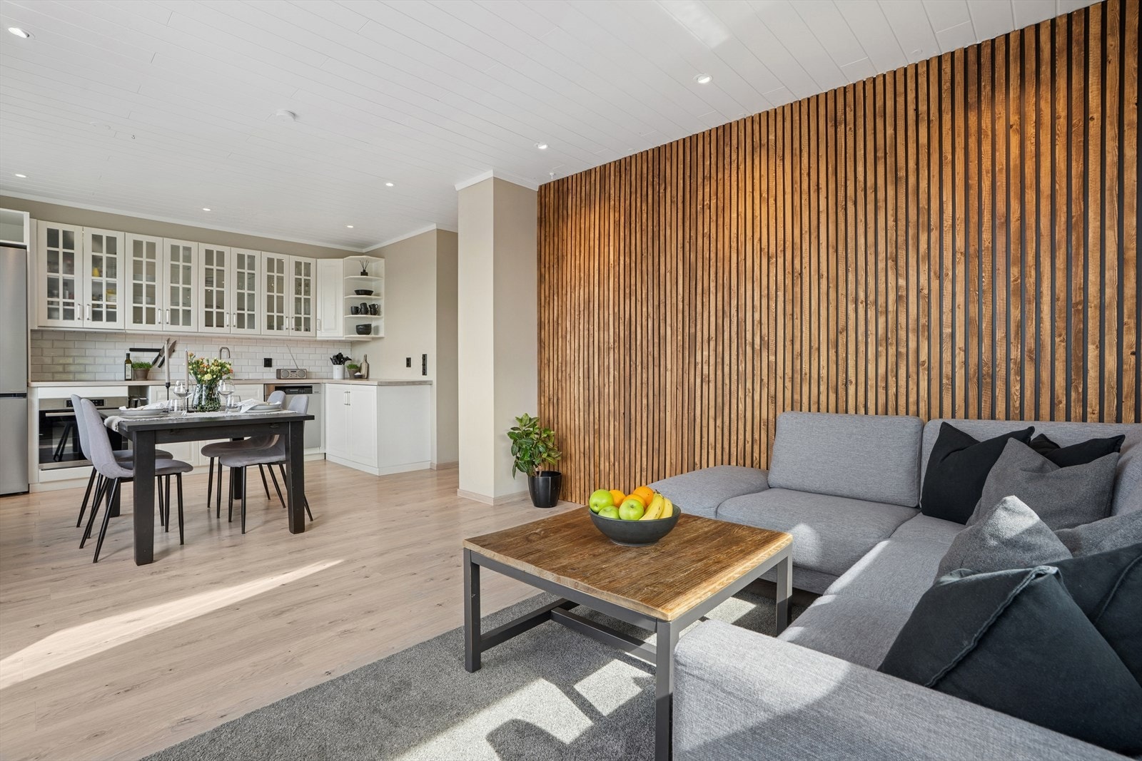 Overflatene i stuen er med lyse vegger og spilevegg som gir rommet et moderne preg. Galleribilde