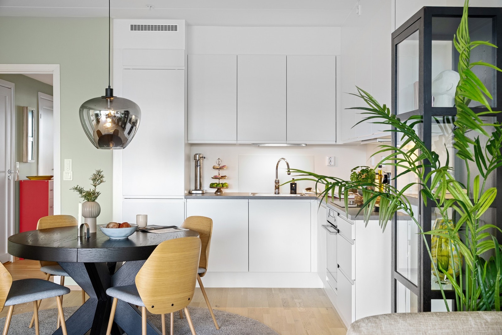 Den hvite innredningen med glatte fronter står i elegant kontrast til benkeplaten i laminat med nedfelt stålkum. Galleribilde