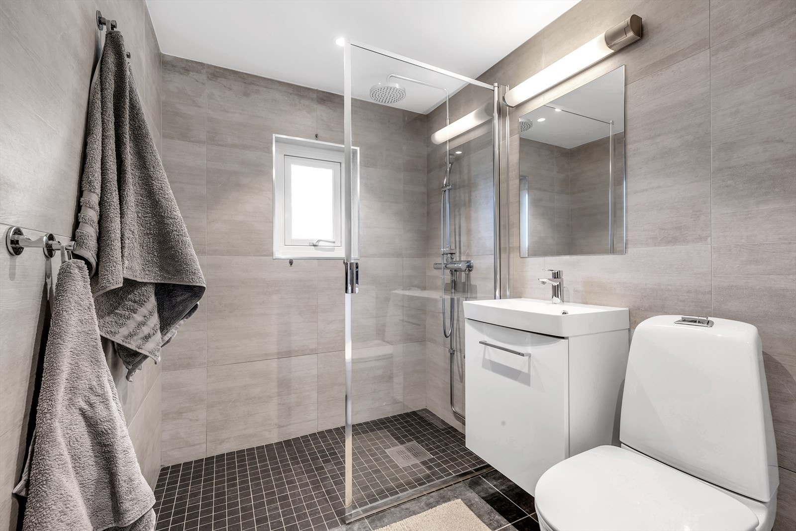 Innredningen består av wc, dusjvegg, servant med underskap, speil med overlys, elektriske varmekabler i gulv og opplegg for vaskemaskin. Galleribilde