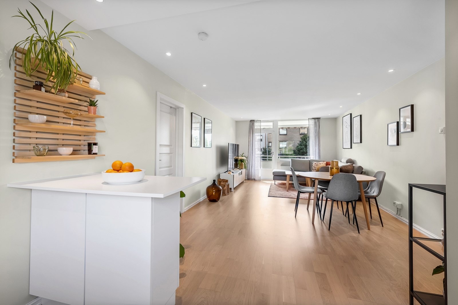 Romslig og luftig stue med parkett på gulv, malte slette vegger og downlights i tak. Det er god plass til spisestue mellom kjøkkenet og stuen. Galleribilde