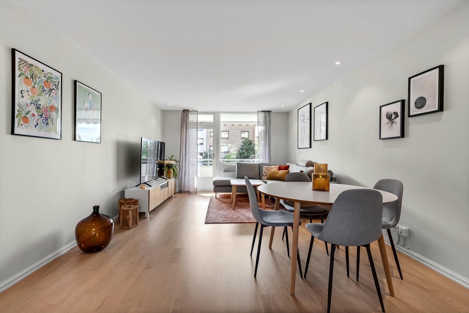 Romslig og luftig stue med parkett på gulv, malte slette vegger og downlights i tak. Det er god plass til spisestue mellom kjøkkenet og stuen. Galleribilde