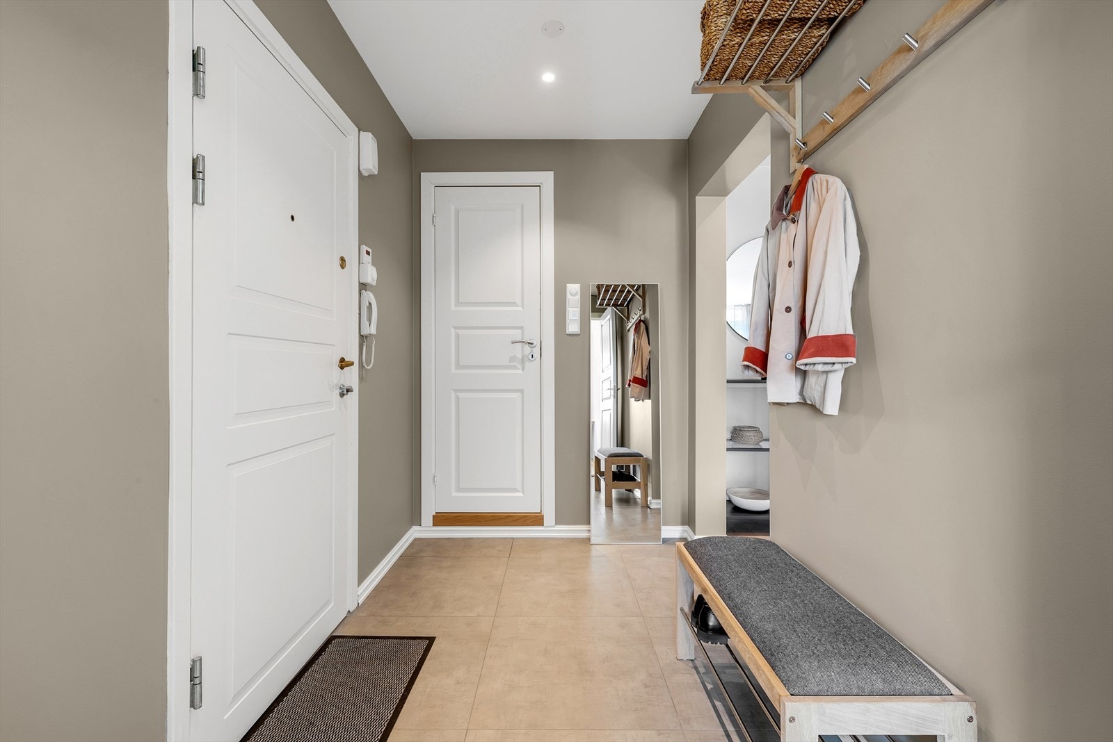 Entré med fliser på gulv, malte slette vegger og malt tak med downlights. Galleribilde