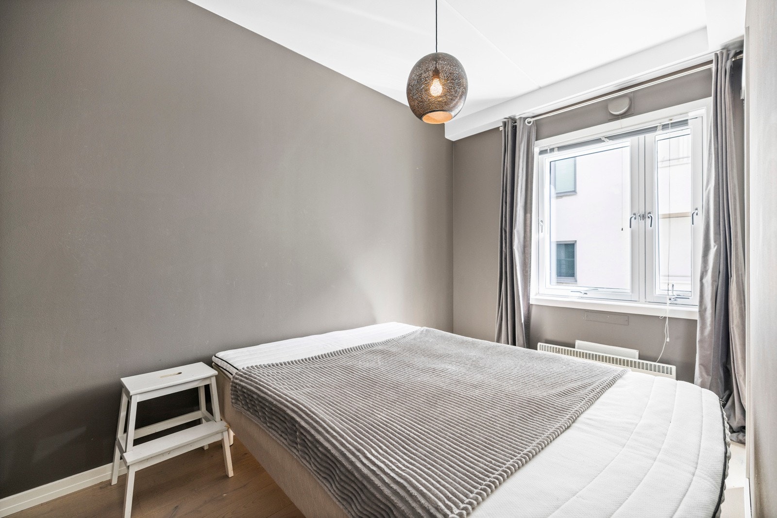 Stort vindu bidrar til et lyst og luftig soverom. Galleribilde