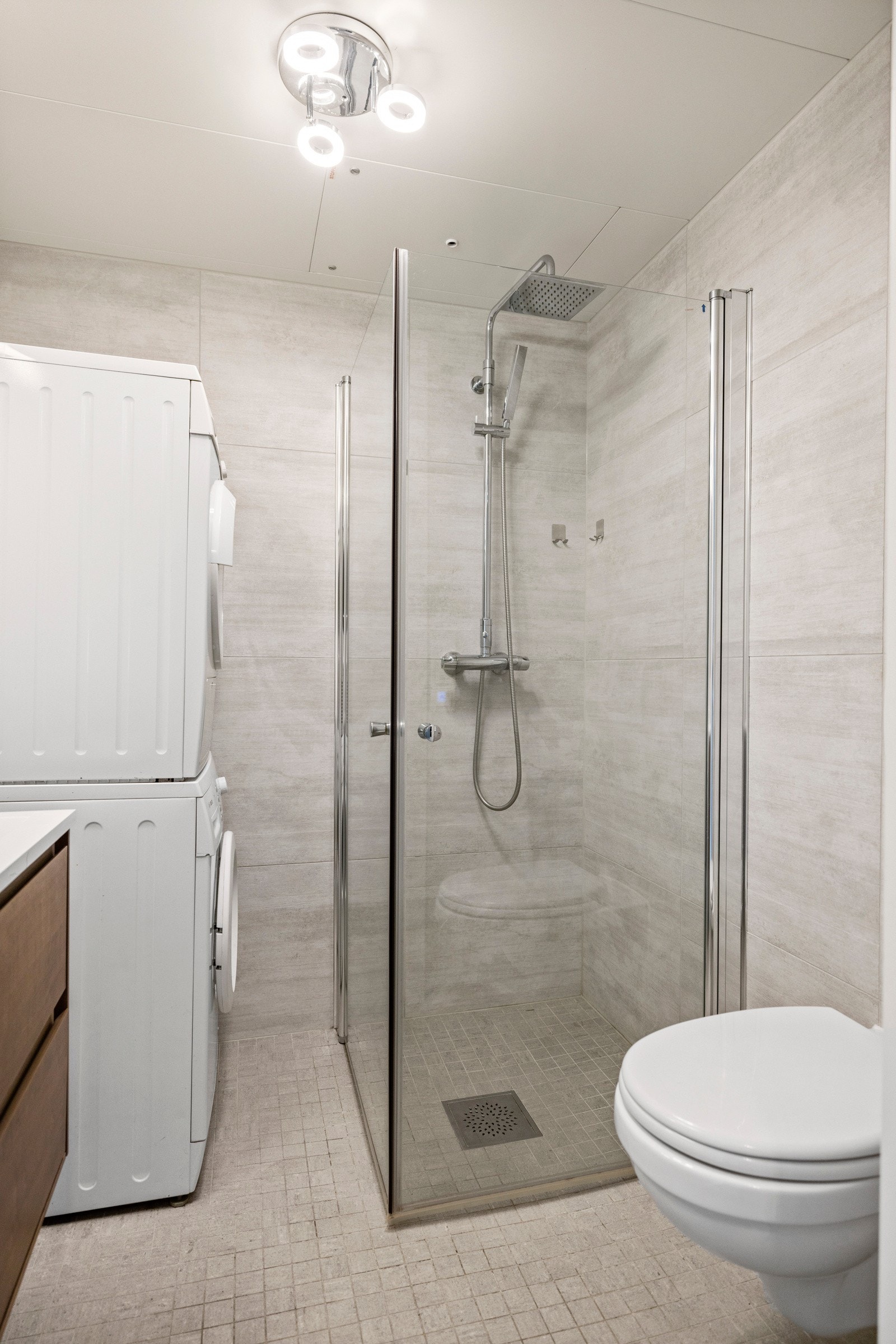 Baderomsinnredning med modulskap med skuffer og toppmontert servant av porselen og med ett-greps blandebatteri. Opplegg til vaskemaskin og tørketrommel. Galleribilde