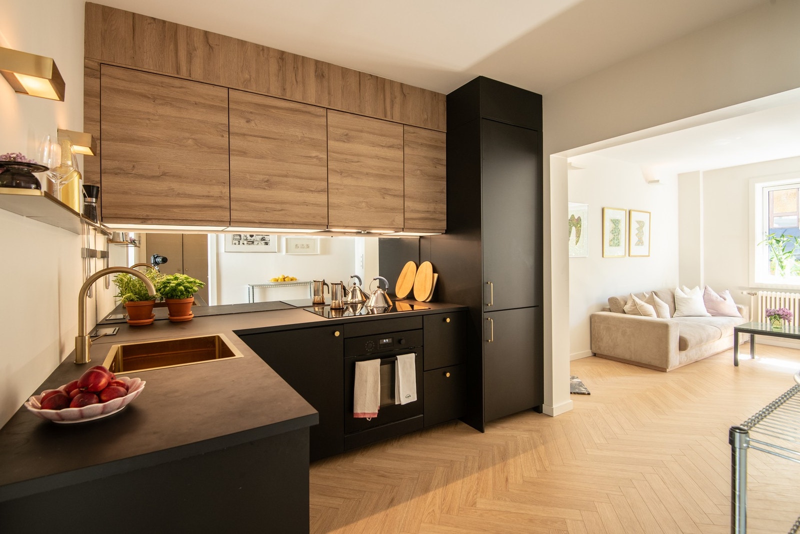 Kjøkkeninnredningen har et stilrent uttrykk preget av glatte fronter med integrerte håndtak, delikat kombinert med messingknotter for et eksklusivt preg. Galleribilde