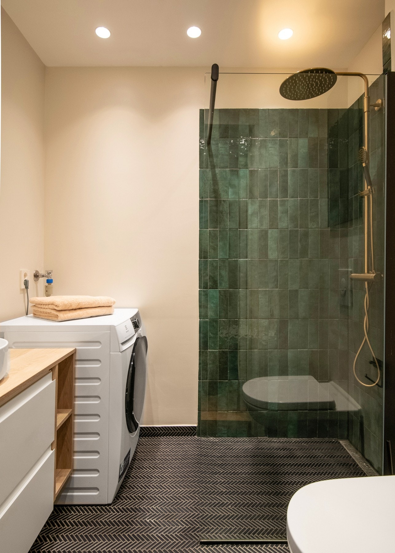 Videre er badet utstyrt med veggmontert toalett og et dusjhjørne med fastmontert dusjvegg i herdet glass. Galleribilde