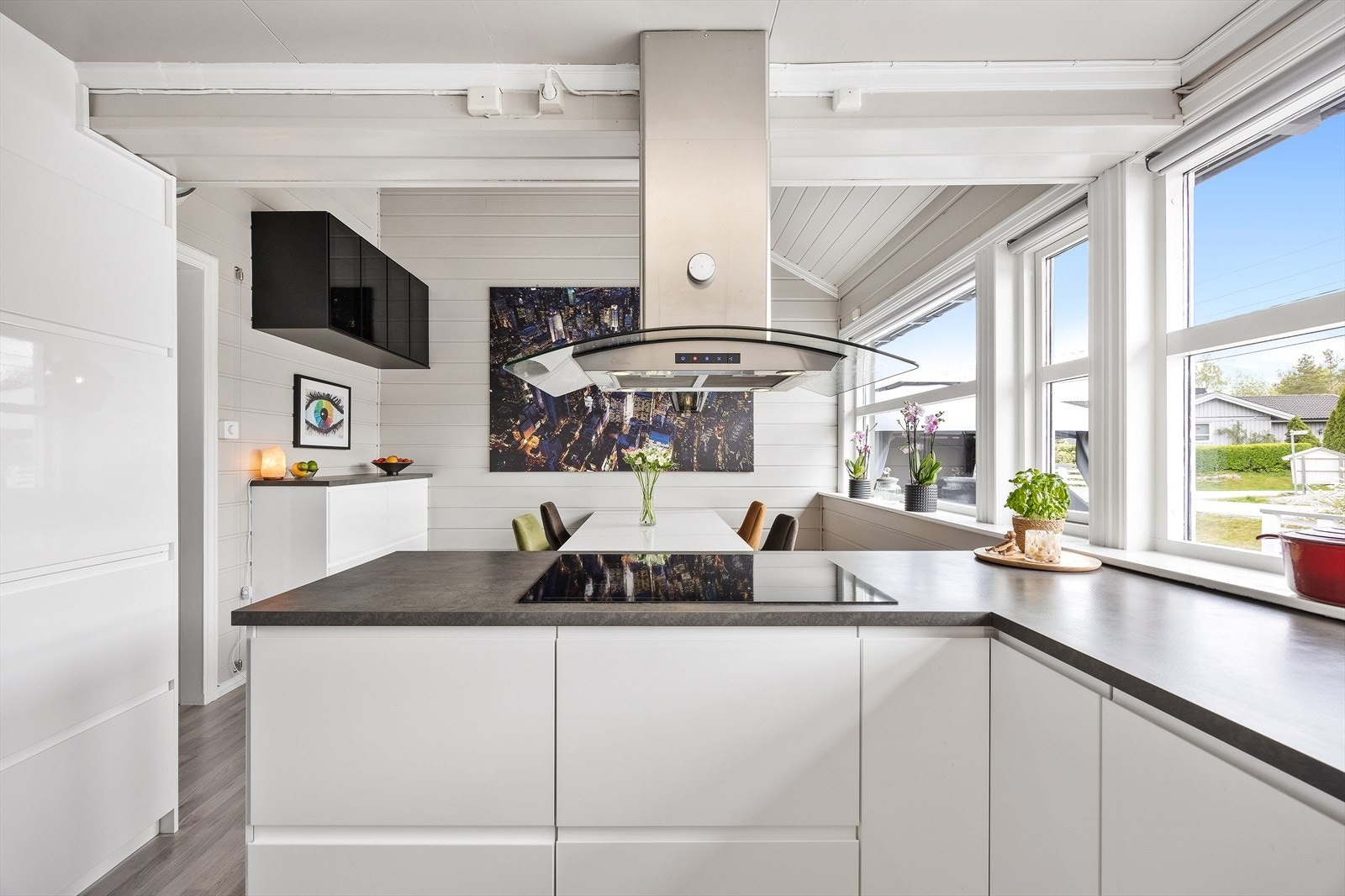 Innredningen består av hvite/glatte fronter, mørk benkeplate, kitchenboard, belysning under overskap og underlimt vask. Galleribilde