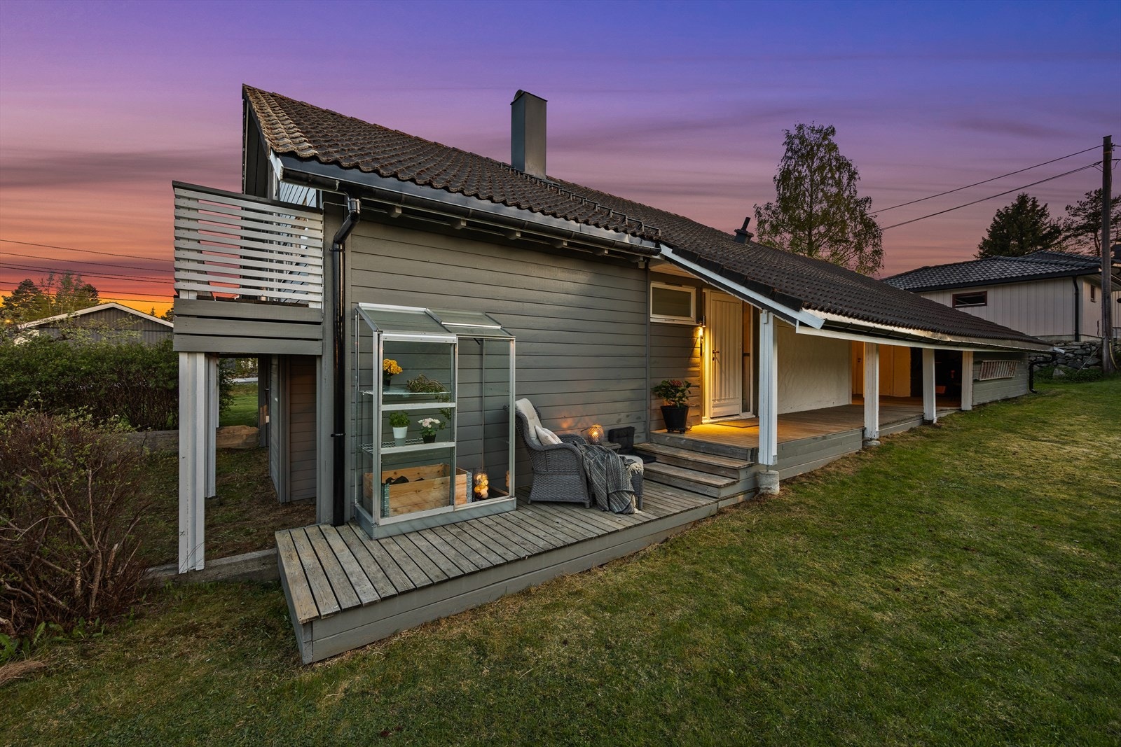 Fra inngangspartiet er det nedgang til en platting med et lite drivhus og plass til en koselig sittegruppe. Galleribilde