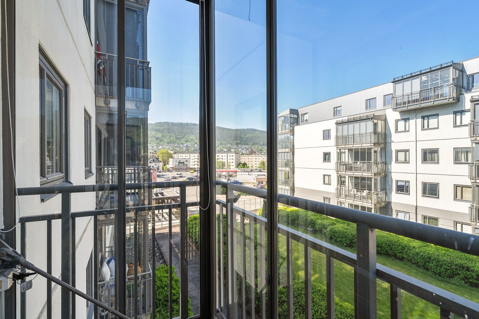 Fellesareal hevet over bakkeplan med plenarealer og beplantning Galleribilde