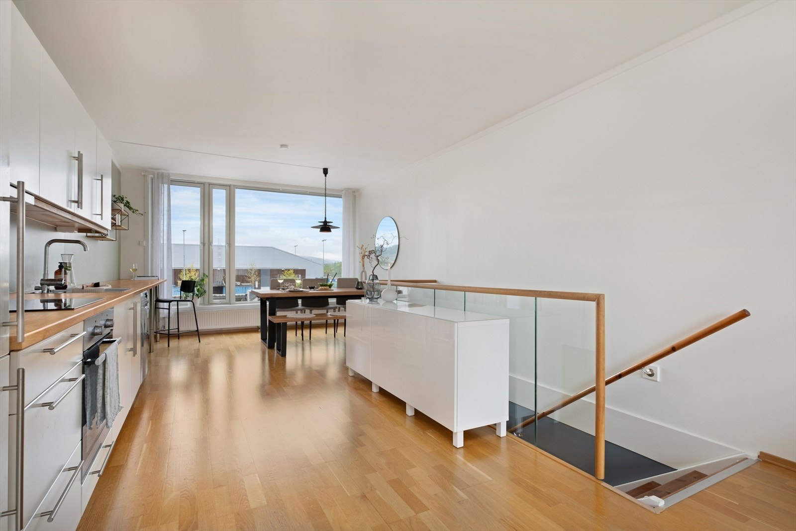 Fra stuen er det en glidende overgang til kjøkkenet. Kjøkkeninnredningen har slette, lyse flater og integrerte hvitevarer. Galleribilde