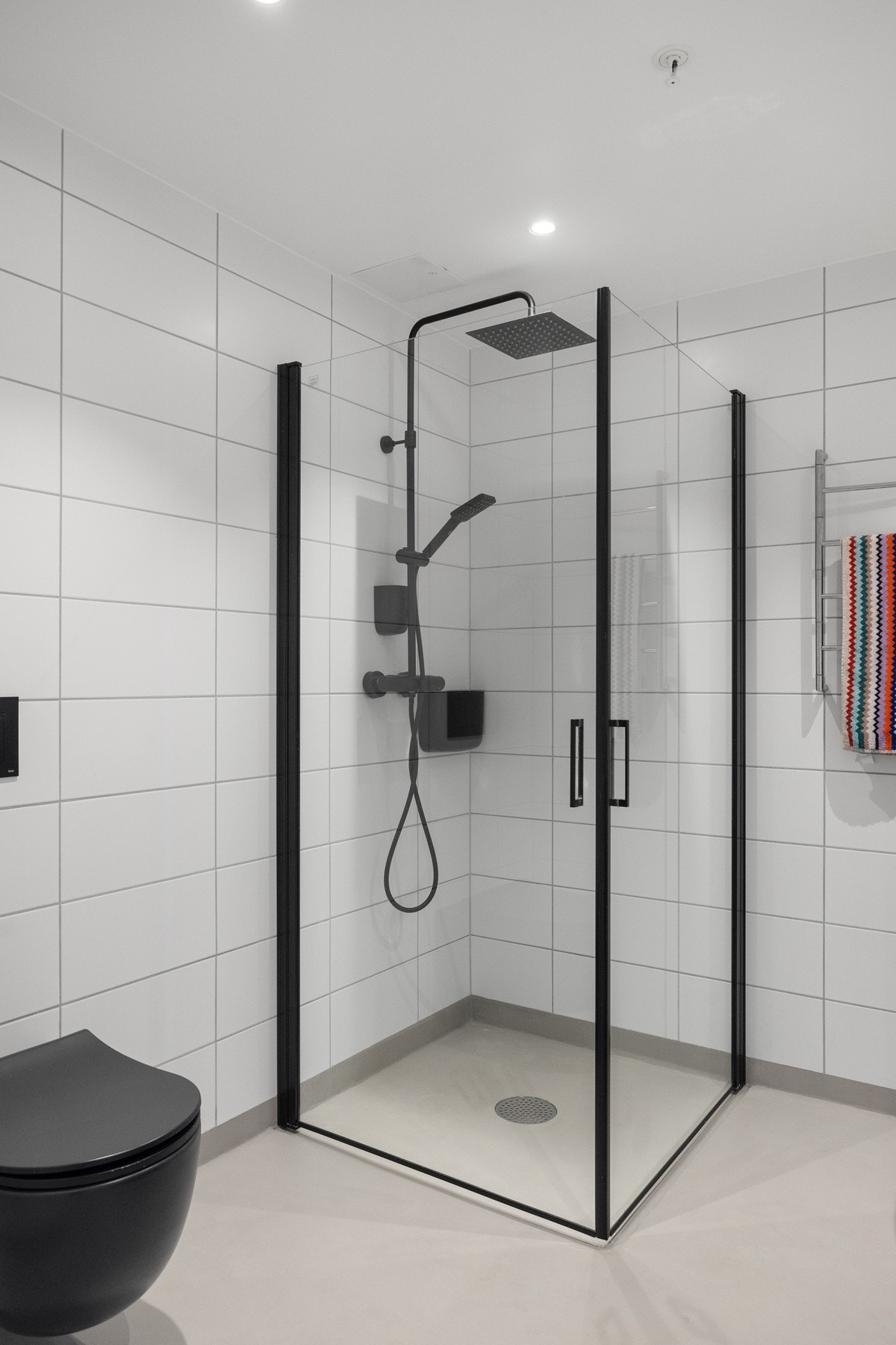 Badet er innredet med servant, vegghengt toalett og dusjhjørne med innfellbare dusjdører. Galleribilde