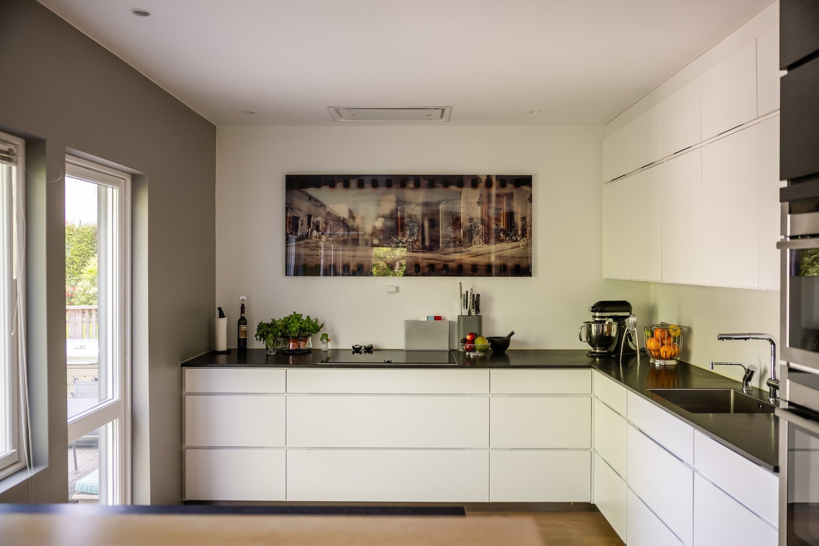 Stilrent Kvik kjøkken med hvite glatte fronter og godt med skap/benkeplass. Kjøkkenvifte praktisk plassert i taket. Galleribilde