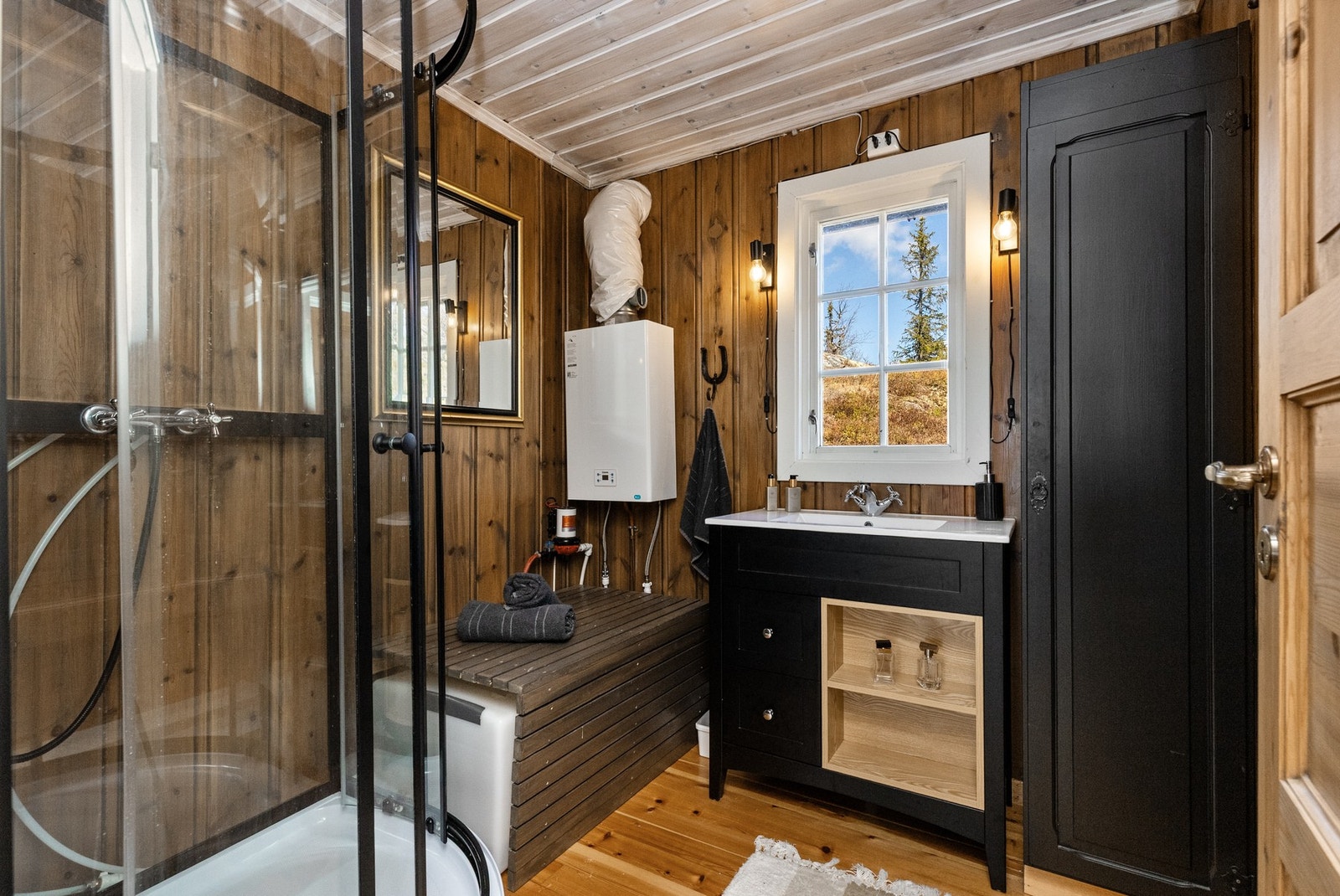 Badet har innredning med nedfelt servarnt, et høyskap i forbindelse med innredning - malt i en sort fargetone Galleribilde