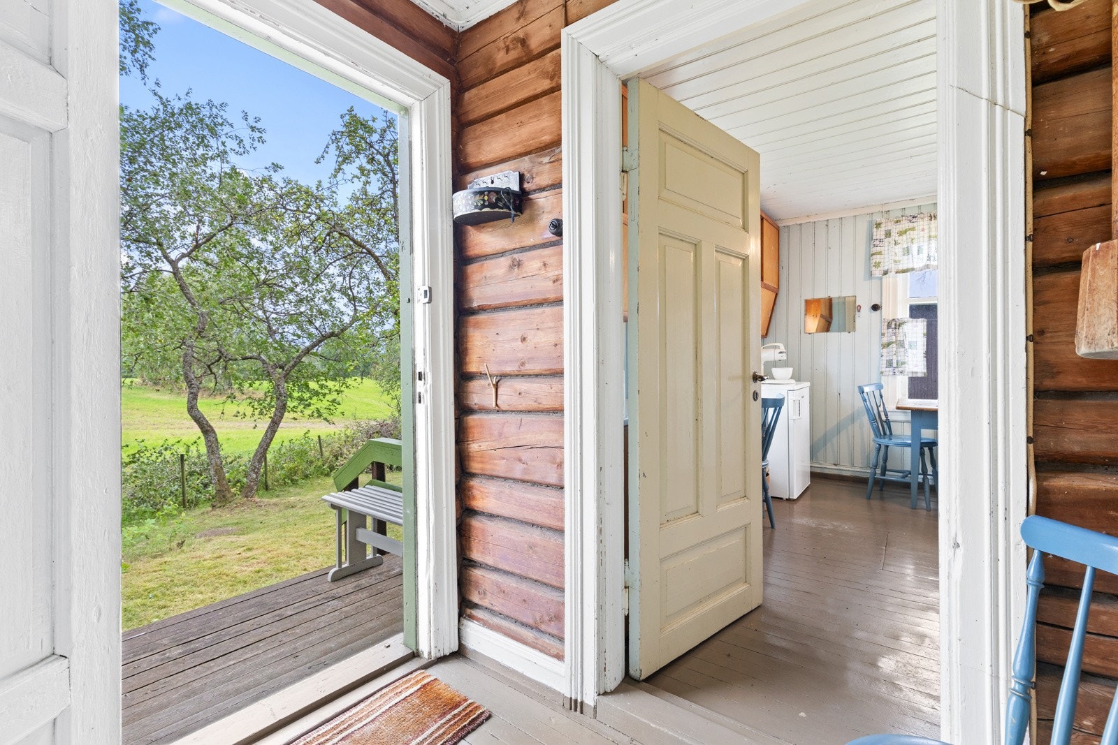 En innbydende entre med malte heltre gulvbord og sjarmerende laftede tømmervegger ønsker deg velkommen inn. Galleribilde