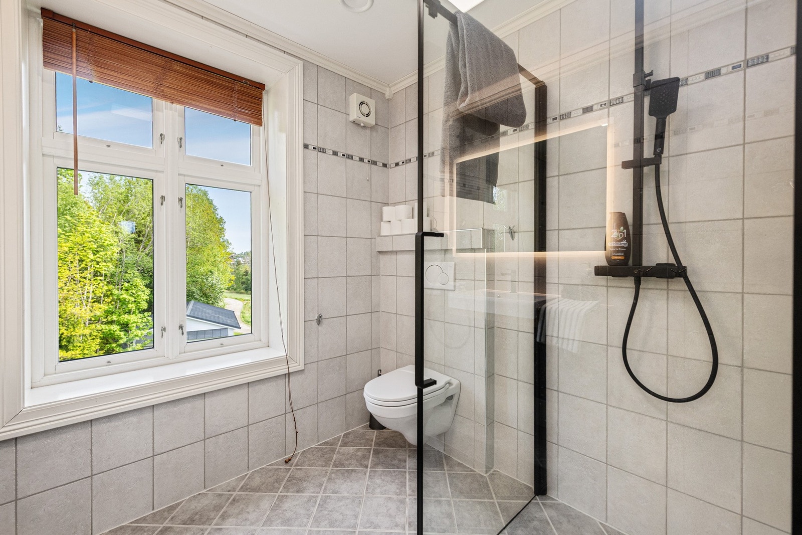 Dusjsonen består av dusjhjørne med glassdører og regndusj, og det er vegghengt toalett med innebygd sisterne. Galleribilde