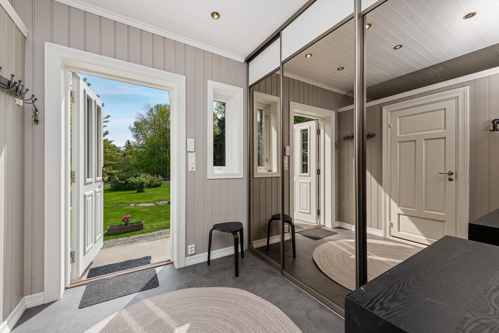 Inngangspartiet leder deg inn i en romslig gang med flislagt gulv og god plass til garderobeløsning, kommode eller sittebenk. Galleribilde