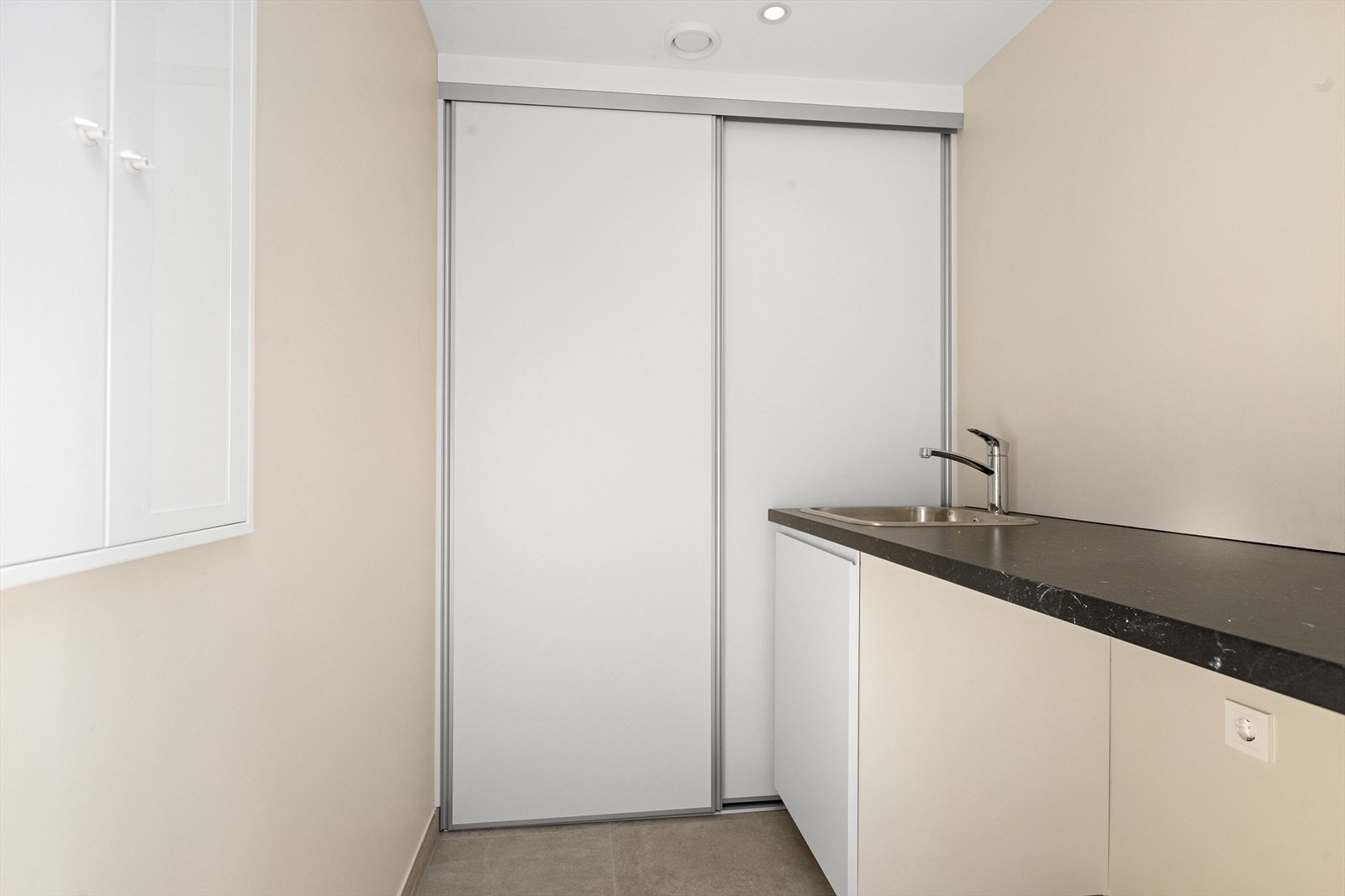 Vaskerom/teknisk rom har fliser på gulv med vannbåren gulvvarme og malte gipsvegger. Malt gipstak med innfelte LED downlights med dimmer. Skyvedør mot teknisk vegg. Varmtvannsbereder og balansert ventilasjon. Innredning med utslagsvask, benkeplate og skap Galleribilde